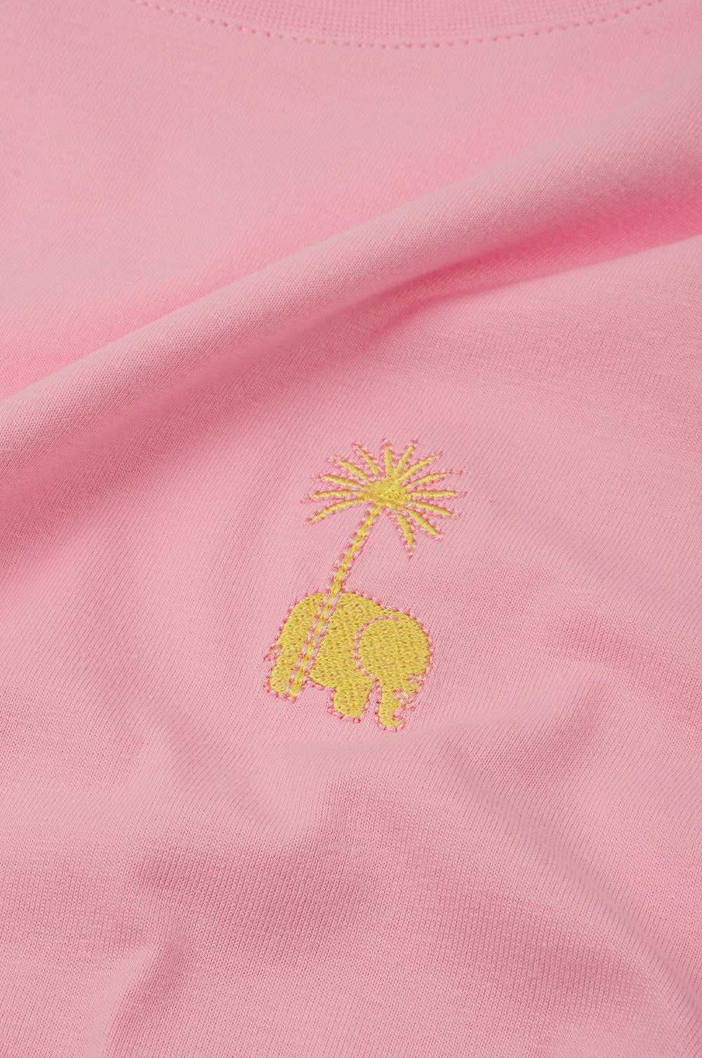 Détail en gros plan du tissu rose bubble gum avec un motif éléphant brodé et un palmier | TP_IMAGE_TYPE=DETAIL