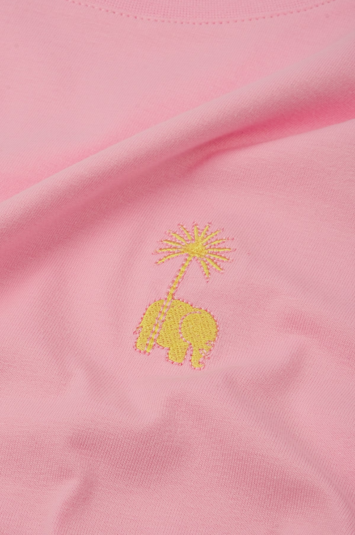Détail en gros plan du tissu rose bubble gum avec un motif éléphant brodé et un palmier | TP_IMAGE_TYPE=DETAIL