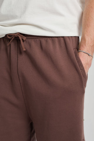Persona che indossa Essentials Sweatshorts in Shaved Chocolate, con elastico in vita e tasche laterali in evidenza | TP_IMAGE_TYPE=DETAIL