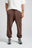 Persona che indossa Essential Sweatpants in Shaved Chocolate, con una vestibilità rilassata e coulisse in vita | TP_IMAGE_TYPE=MODEL_FRONT