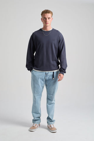Persona che indossa una Essential Sweatshirt in Parisian Blue, abbinata a jeans azzurri e sneakers, per un look casual. | TP_IMAGE_TYPE=MODEL_FRONT