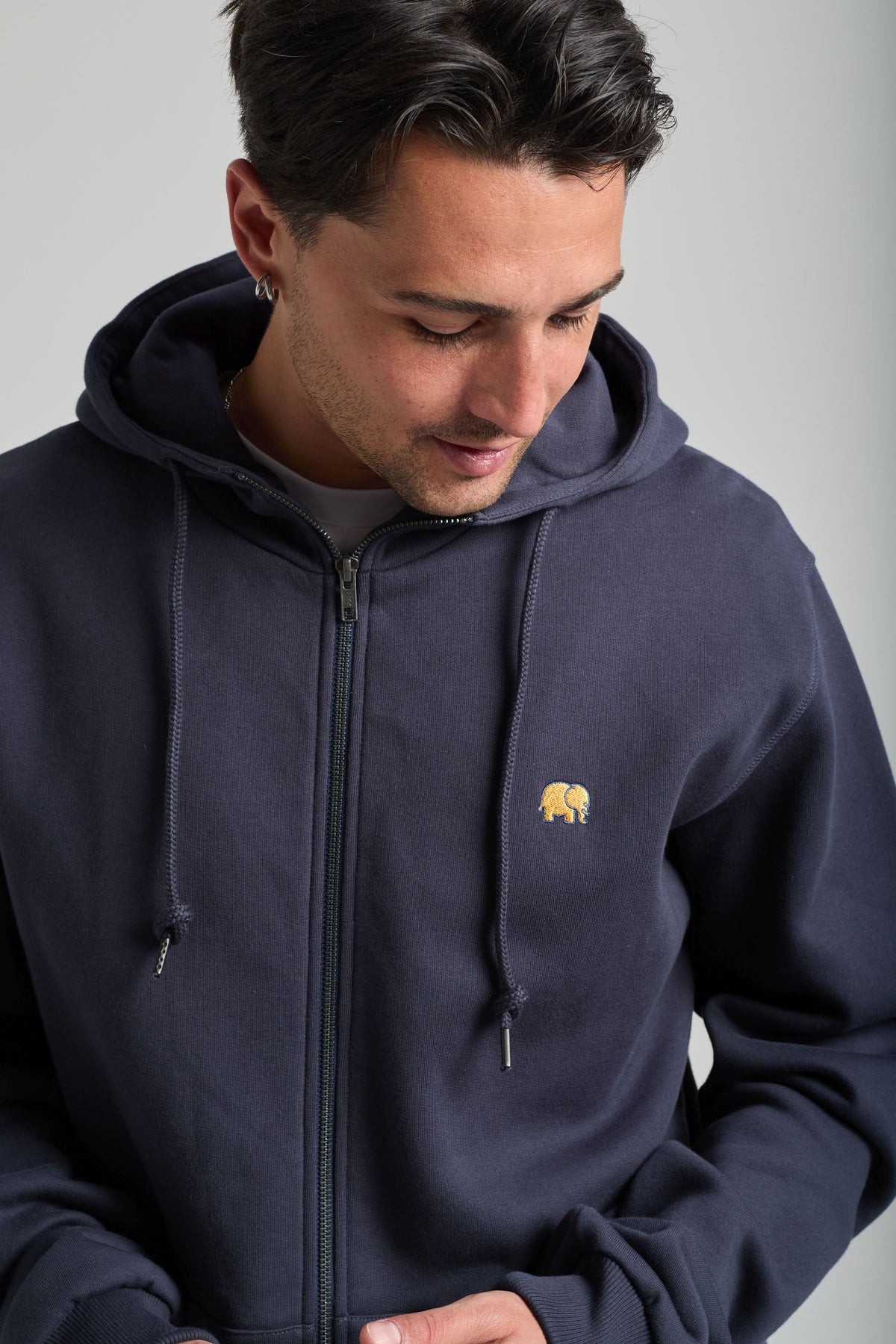 Personne portant un sweat à capuche zippé Organic Essential Zip Hoodie Trendsplant Blue avec un discret logo éléphant, vue de face | TP_IMAGE_TYPE=MODEL_FRONT