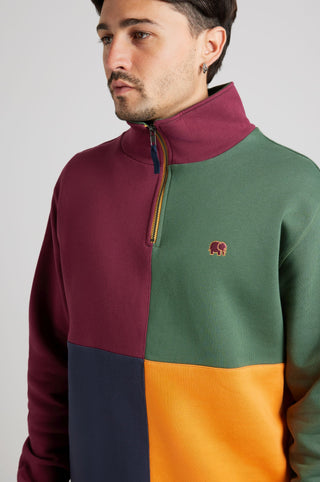 Persona che indossa una felpa Color Block half zip "Harlequin" con pannelli bordeaux, verde, blu navy e arancione, dal design elegante e moderno. | TP_IMAGE_TYPE=MODEL_FRONT