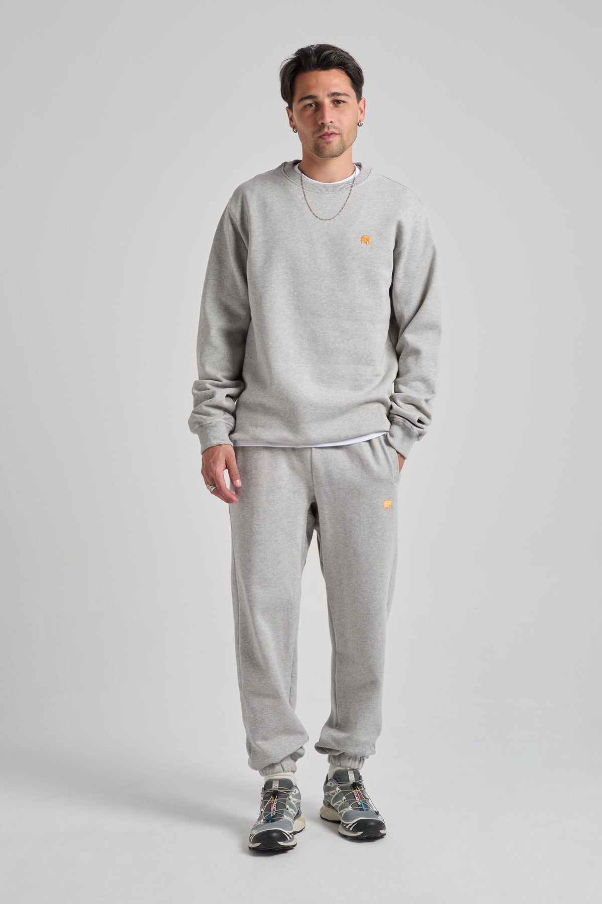 Persona che indossa una Organic Essential Sweatshirt in Heather Grey, in posizione eretta con uno sfondo neutro | TP_IMAGE_TYPE=MODEL_FRONT