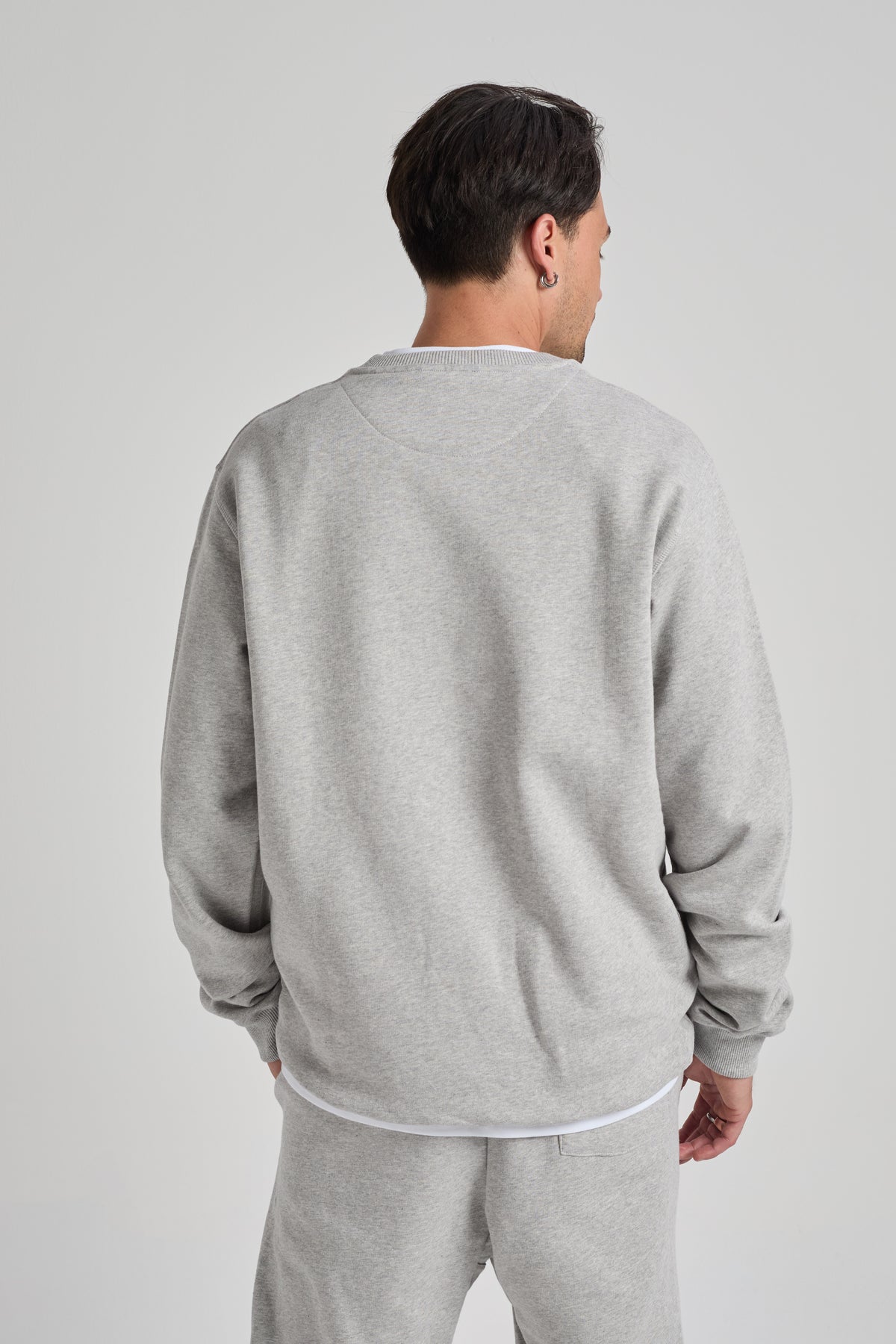 Persona che indossa una Organic Essential Sweatshirt in Heather Grey, vista di spalle | TP_IMAGE_TYPE=MODEL_BACK