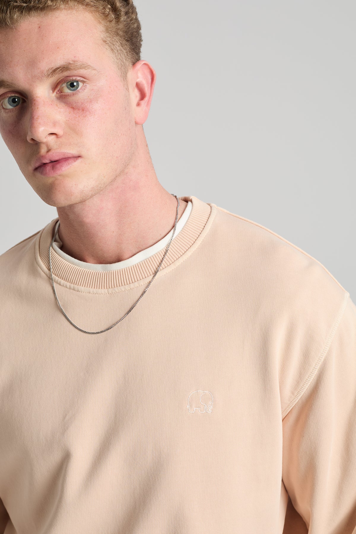 Persona che indossa Essential Sunwashed Sweatshirt in Smoke Gray, con tessuto dalla texture marcata e vestibilità casual. | TP_IMAGE_TYPE=MODEL_FRONT