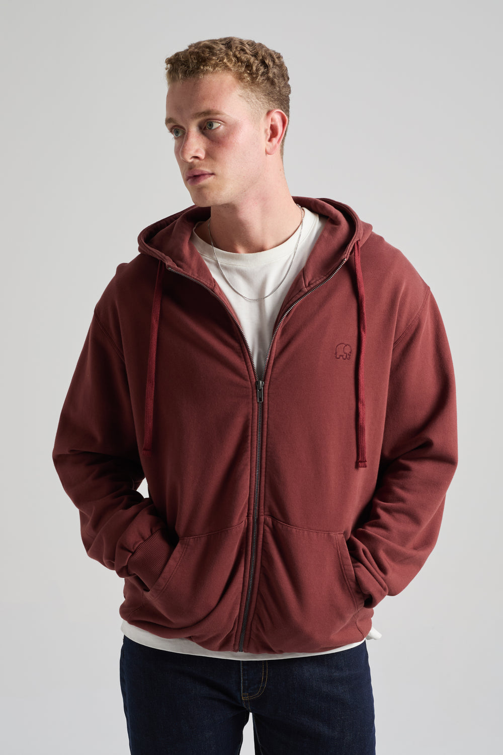 Persona che indossa Essential Zip Hoodie in Andorra Brown con chiusura lampo e cappuccio, abbinato a una t-shirt bianca sotto. | TP_IMAGE_TYPE=MODEL_FRONT