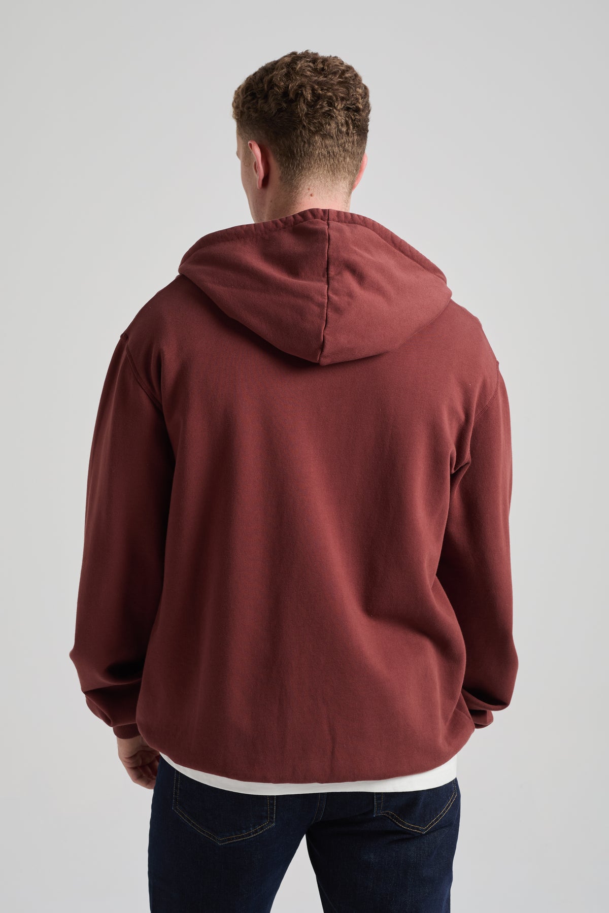 Persona che indossa una Essential Zip Hoodie in Andorra Brown, con vista posteriore del design elegante e confortevole. | TP_IMAGE_TYPE=MODEL_BACK