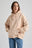 Persona che indossa una felpa beige e jeans blu su sfondo neutro. TP_IMAGE_TYPE=MODEL_FRONT