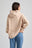 Persona che indossa una felpa beige e jeans blu su sfondo grigio chiaro. TP_IMAGE_TYPE=MODEL_BACK