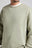 Personne portant un Essential Sunwashed Sweatshirt en coloris Seagrass, avec une encolure ronde et un discret détail logo. | TP_IMAGE_TYPE=MODEL_FRONT