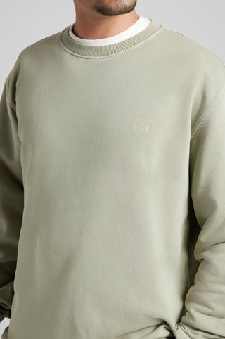 Personne portant un Essential Sunwashed Sweatshirt en coloris Seagrass, avec une encolure ronde et un discret détail logo. | TP_IMAGE_TYPE=MODEL_FRONT
