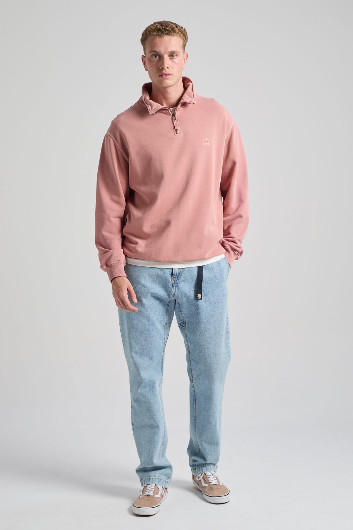 Person wearing an Essential Sunwashed Quarter Zip Sweatshirt in Old Rose, styled with light blue jeans and sneakers. | TP_IMAGE_TYPE=MODEL_FRONT