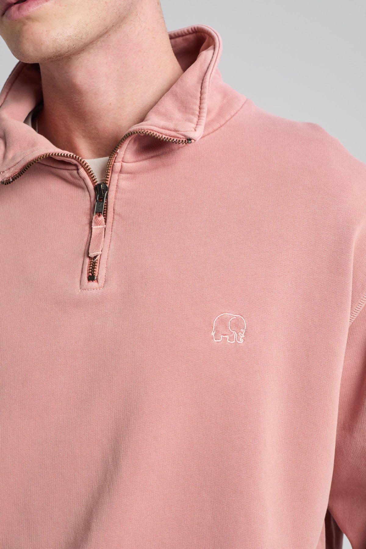 Person wearing Essential Sunwashed Quarter Zip Sweatshirt in Old Rose, featuring a half-zip collar and embroidered elephant logo. | TP_IMAGE_TYPE=MODEL_FRONT