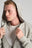 Persona che indossa una Essential Sunwashed Zip Hoodie in Natural Gray, con chiusura zip frontale e vestibilità rilassata, che mette in risalto il tessuto morbido e il cappuccio. | TP_IMAGE_TYPE=MODEL_FRONT