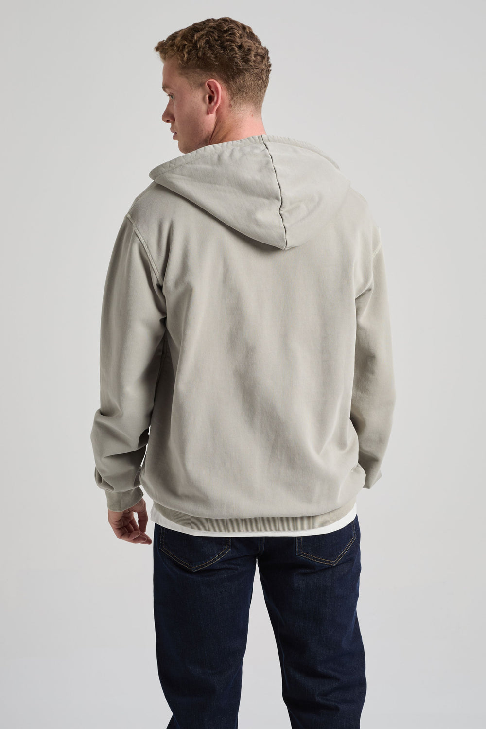 Persona che indossa Essential Sunwashed Zip Hoodie in Natural Gray, vista di spalle | TP_IMAGE_TYPE=MODEL_BACK