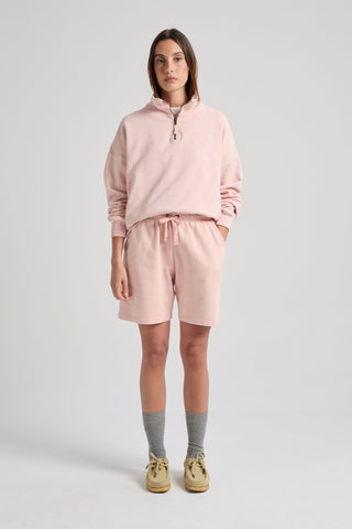 Persona che indossa Women's Sunwashed Essential Quarter Zip Sweatshirt in Lotus Pink, abbinata a shorts coordinati e calze grigie. | TP_IMAGE_TYPE=MODEL_FRONT