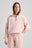 Persona che indossa una Sunwashed Essential Quarter Zip Sweatshirt da donna in lotus pink, abbinata a shorts coordinati, con lo sguardo rivolto di lato su sfondo neutro. | TP_IMAGE_TYPE=MODEL_FRONT