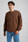 Person wearing an Essential Sweatshirt in Carafe Brown, paired with light blue jeans, standing against a neutral background. | TP_IMAGE_TYPE=MODEL_FRONT