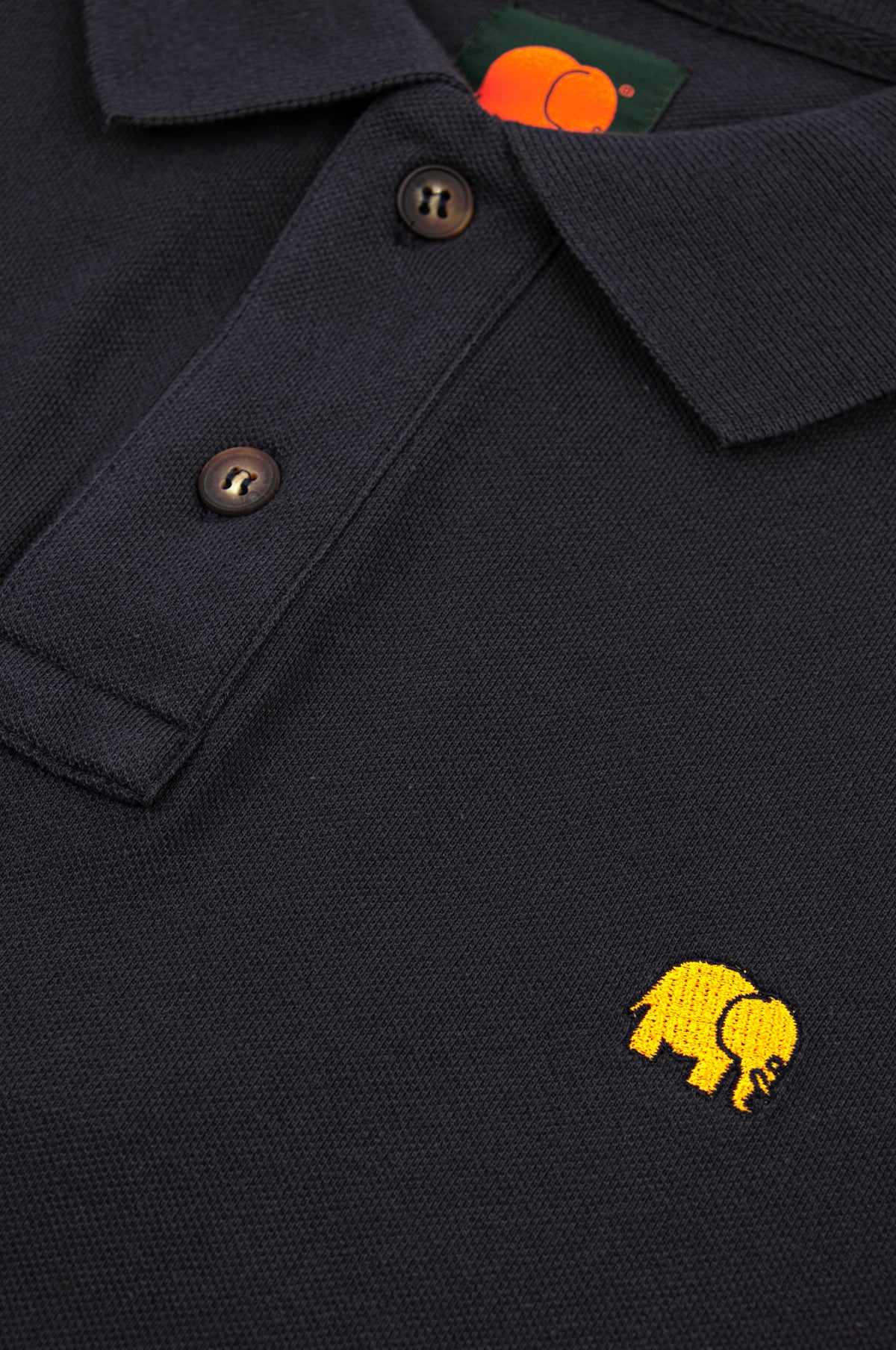Détail en gros plan du polo Organic Essential Polo Shirt en Trendsplant Blue, avec boutons et logo éléphant brodé | TP_IMAGE_TYPE=DETAIL