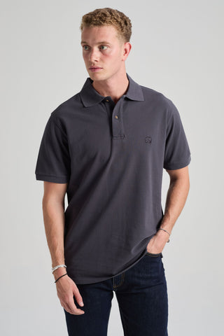 Personne portant l'Essential Polo en Bitumen Grey, porté de façon décontractée avec un jean foncé | TP_IMAGE_TYPE=MODEL_FRONT