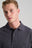 Personne portant un Essential Polo en Bitumen Grey, avec col classique et discret logo brodé. | TP_IMAGE_TYPE=MODEL_FRONT