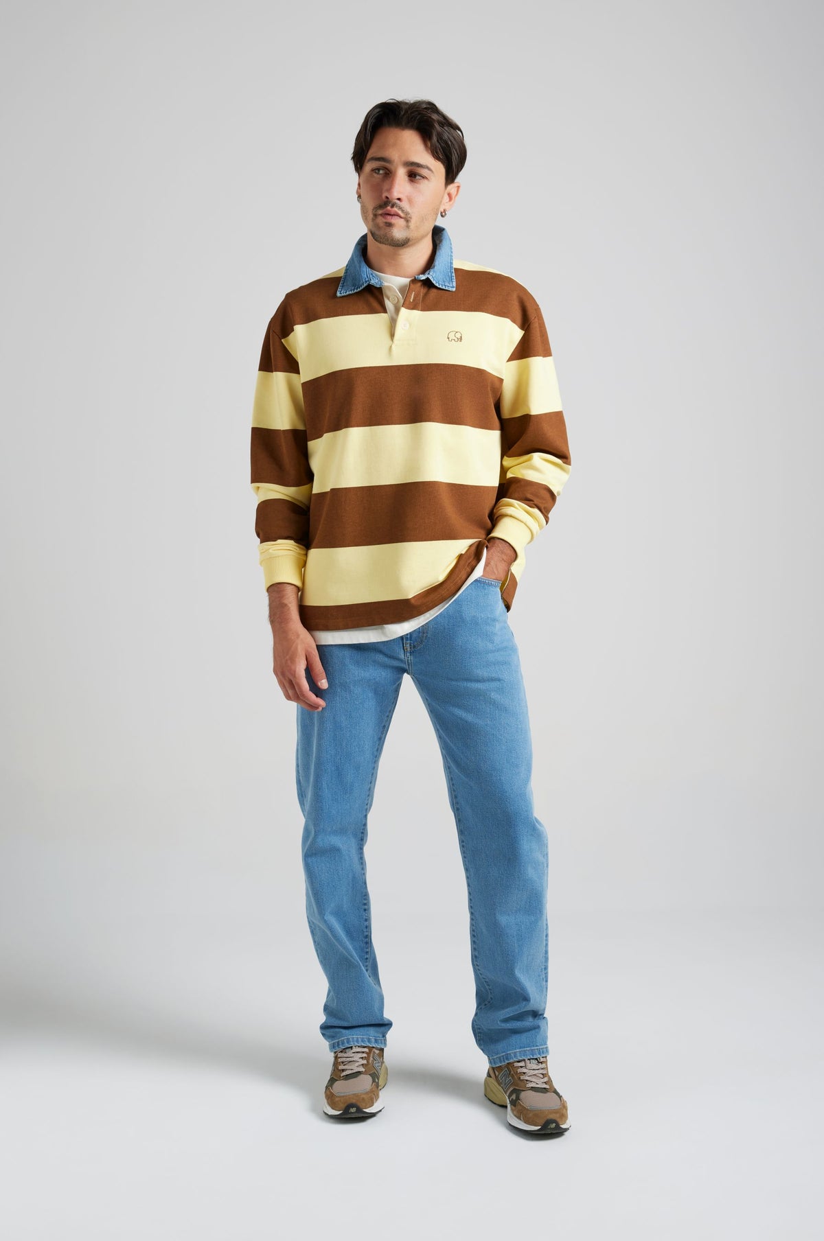 Personne portant un Yard Rugby Polo à rayures Cappuccino et Banana, associé à un jean en denim et des baskets, debout sur un fond clair. | TP_IMAGE_TYPE=MODEL_FRONT