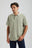 Person wearing an Essential Sunwashed Polo in Seagrass, showcasing a relaxed fit and subtle branding. | TP_IMAGE_TYPE=MODEL_FRONT