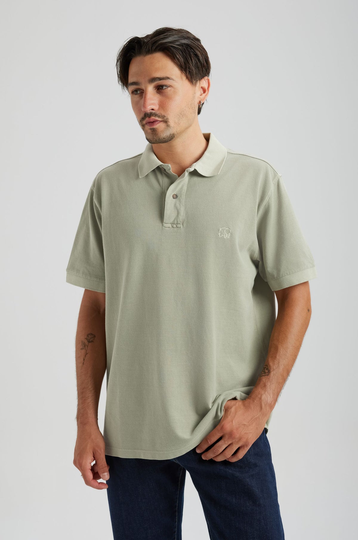 Person wearing an Essential Sunwashed Polo in Seagrass, showcasing a relaxed fit and subtle branding. | TP_IMAGE_TYPE=MODEL_FRONT