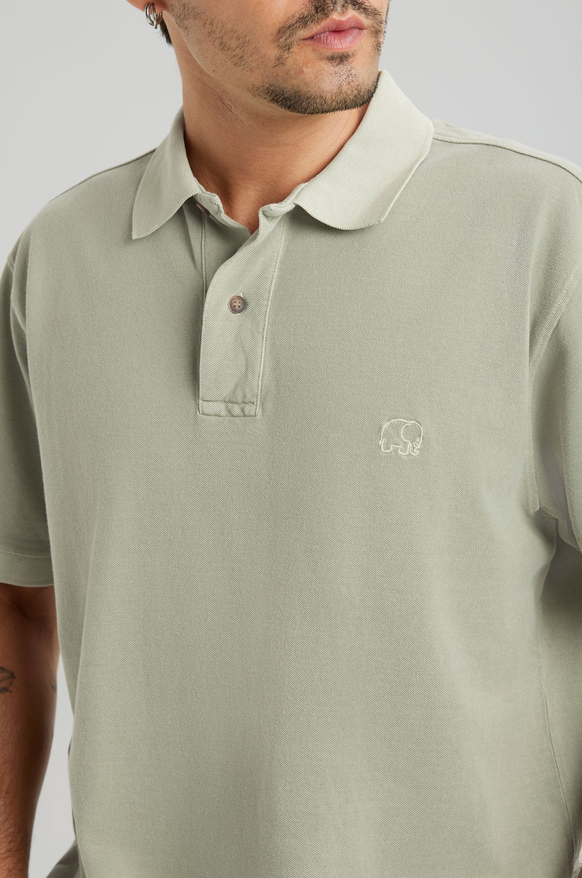 Person wearing an Essential Sunwashed Polo in Seagrass, showcasing the classic collar and embroidered detail | TP_IMAGE_TYPE=MODEL_FRONT