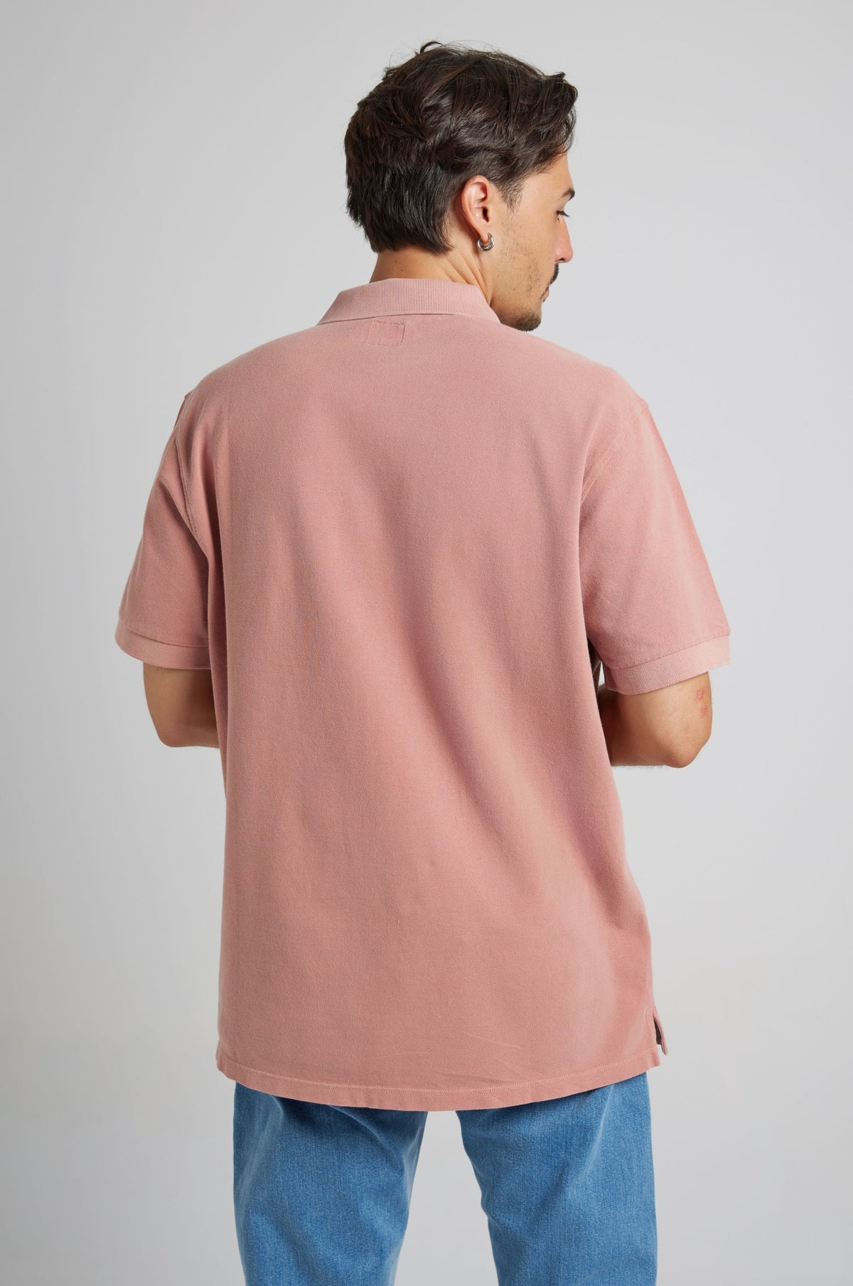 Persona che indossa Essential Sunwashed Polo in Old Rose, vista da dietro | TP_IMAGE_TYPE=MODEL_BACK