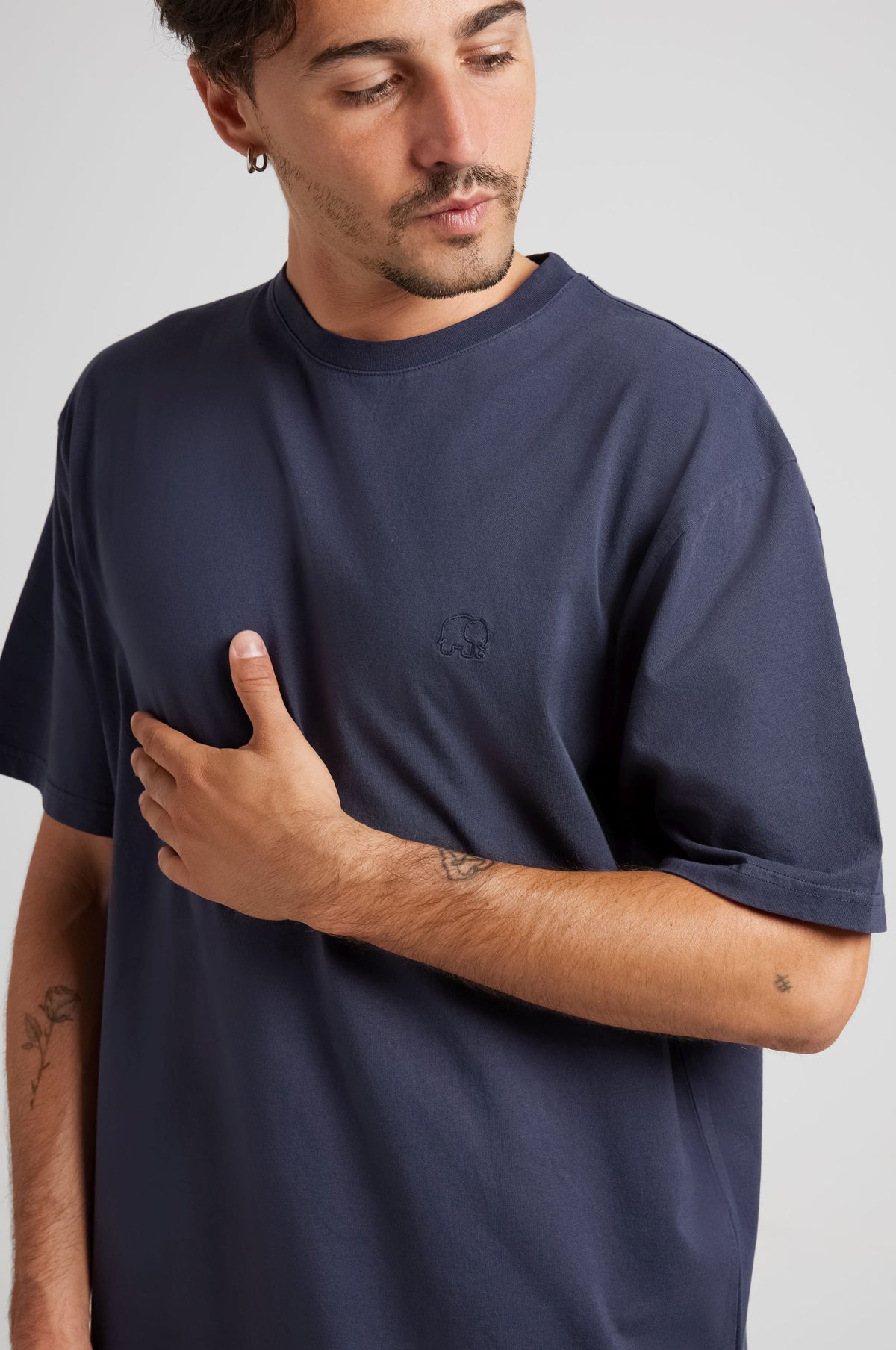 Personne portant un Essential T-Shirt en Parisian Blue, montrant la vue de face avec un gros plan du détail de la marque sur la poitrine | TP_IMAGE_TYPE=MODEL_FRONT