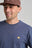 Persona che indossa una Organic Essential T-Shirt in Trendsplant Blue con un piccolo logo elefante ricamato | TP_IMAGE_TYPE=MODEL_FRONT