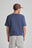 Persona che indossa una T-Shirt Organic Essential in Trendsplant Blue, vista posteriore | TP_IMAGE_TYPE=MODEL_BACK