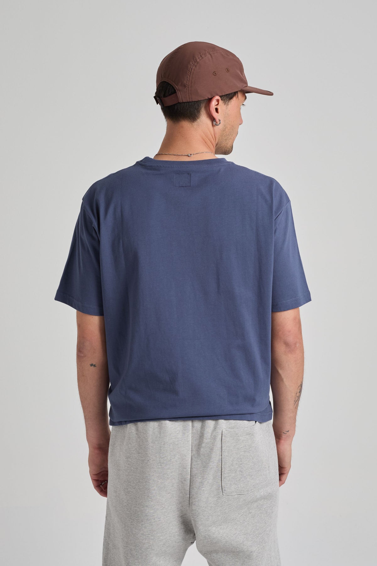 Persona che indossa una T-Shirt Organic Essential in Trendsplant Blue, vista posteriore | TP_IMAGE_TYPE=MODEL_BACK