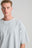 Personne portant le t-shirt oversize Essential Sunwashed Heavyweight en Pearl Blue, avec une coupe décontractée et un design simple. | TP_IMAGE_TYPE=MODEL_FRONT