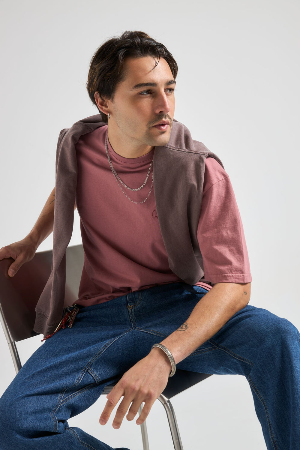Person wearing an Essential Sunwashed T-Shirt in Deco Rose, seated and looking away | TP_IMAGE_TYPE=MODEL_FRONT