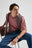Person wearing an Essential Sunwashed T-Shirt in Deco Rose, seated and looking away | TP_IMAGE_TYPE=MODEL_FRONT