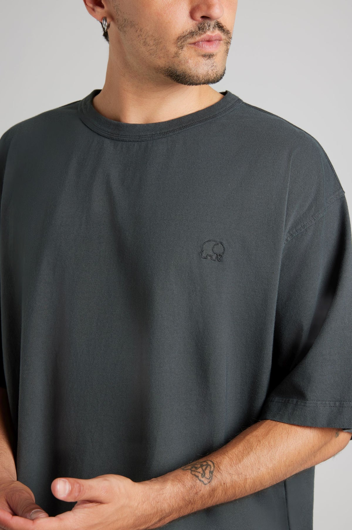 Personne portant un t-shirt épais oversize en Pirate Black, présentant un design simple avec un logo discret sur la poitrine | TP_IMAGE_TYPE=MODEL_FRONT