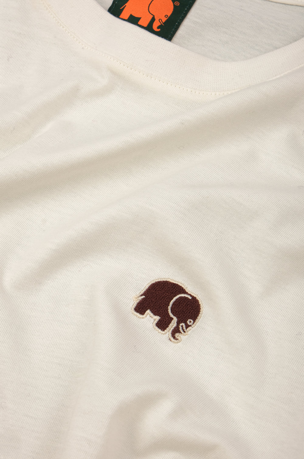 Dettaglio ravvicinato della Organic Essential T-Shirt in Natural con un elefante ricamato sul petto. | TP_IMAGE_TYPE=DETAIL