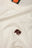 Dettaglio ravvicinato della Organic Essential T-Shirt in Natural con un elefante ricamato sul petto. | TP_IMAGE_TYPE=DETAIL