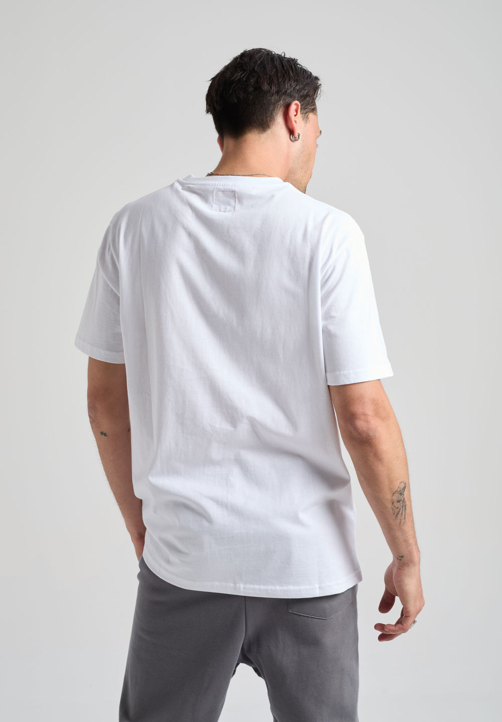 Persona che indossa una Organic Essential T-Shirt bianca, vista posteriore | TP_IMAGE_TYPE=MODEL_BACK