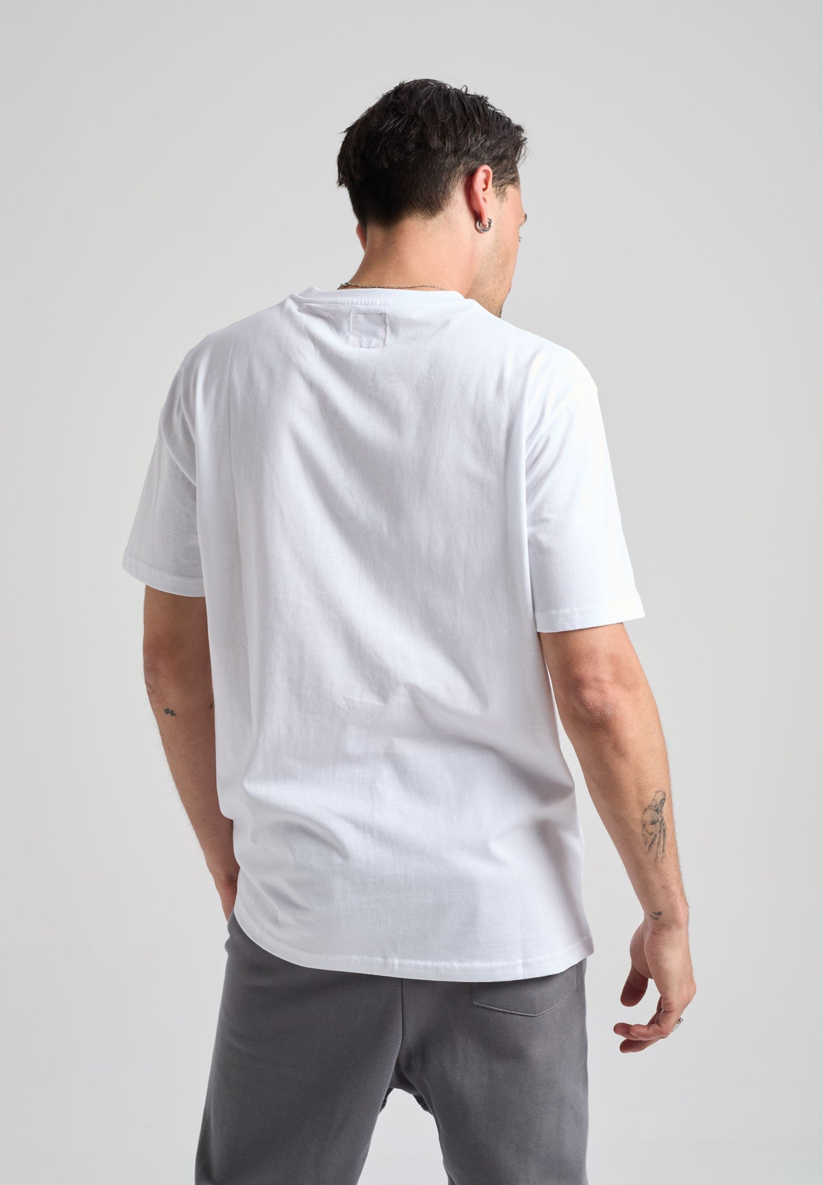 Persona che indossa una Organic Essential T-Shirt bianca, vista posteriore | TP_IMAGE_TYPE=MODEL_BACK