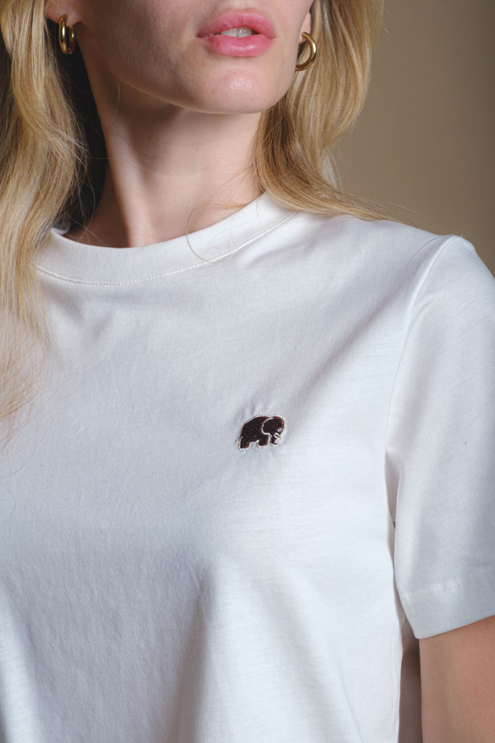 Persona che indossa una Women's Organic Essential T-Shirt in colore naturale, con dettaglio ricamato | TP_IMAGE_TYPE=MODEL_FRONT