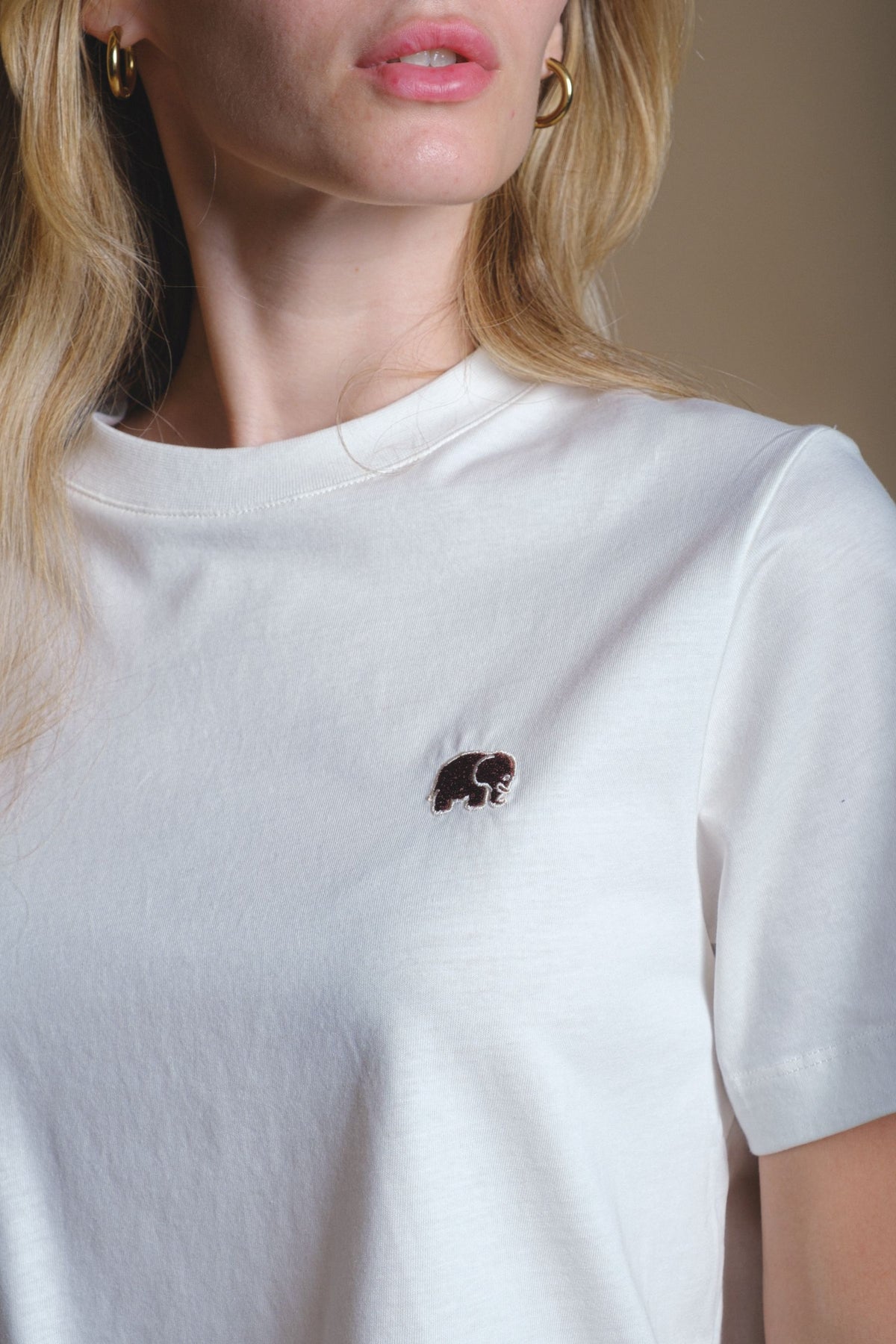 Persona che indossa una Women's Organic Essential T-Shirt in colore naturale, con dettaglio ricamato | TP_IMAGE_TYPE=MODEL_FRONT