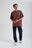 Person wearing an Essential T-Shirt in Puce Purple, styled with dark denim pants and white sneakers, standing casually with hands positioned in front. | TP_IMAGE_TYPE=MODEL_FRONT