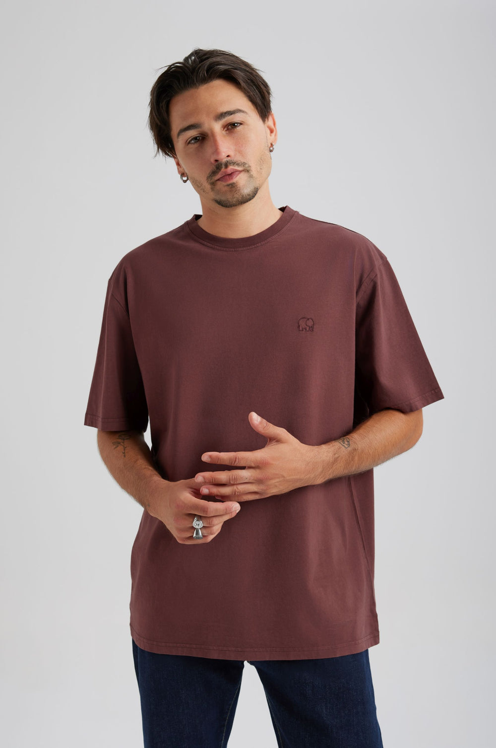 Person wearing an Essential T-Shirt in Puce Purple, with short sleeves and a relaxed fit, styled with navy blue jeans. | TP_IMAGE_TYPE=MODEL_FRONT