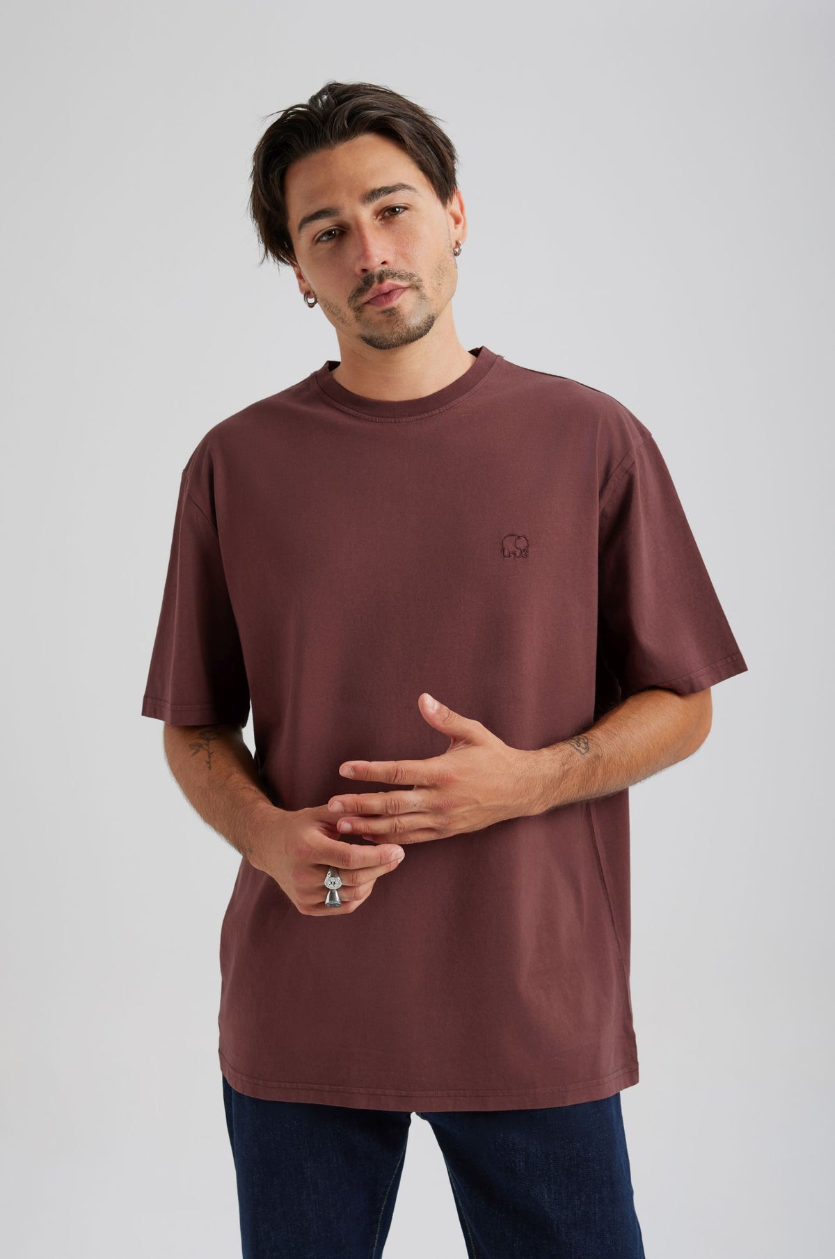 Person wearing an Essential T-Shirt in Puce Purple, with short sleeves and a relaxed fit, styled with navy blue jeans. | TP_IMAGE_TYPE=MODEL_FRONT
