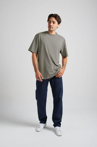 Person wearing an Essential T-Shirt in Brushed Nickel color, styled with dark jeans and white sneakers | TP_IMAGE_TYPE=MODEL_FRONT