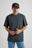 Person wearing an Essential T-Shirt in Bitumen Grey, styled with blue jeans, posing against a neutral background. | TP_IMAGE_TYPE=MODEL_FRONT